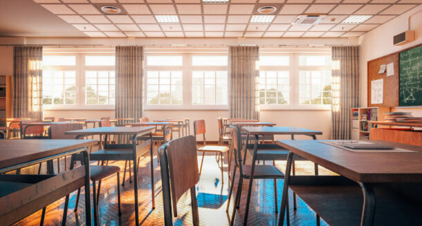 Interior of a traditional school classroom with wooden floor and furniture.