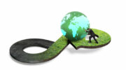 Circular economy concept. Arrow infinity symbol of grass texture with man pushing colourful globe, isolated on white background.