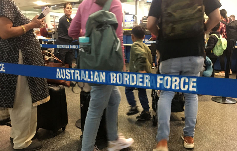 Passengers walking through Australian border force lines