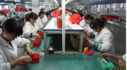Chinese workers assembling lighters in factory.