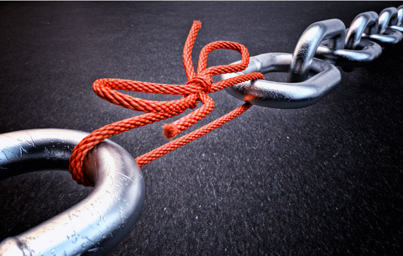 Metallic chain connected by a red knotted rope on black background