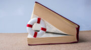 Books half open with a life saver inside. Image: iStock / berkay