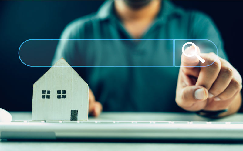 Man clicking internet search page on touch screen with wood home on keyboard. Image: iStock / dontree_m