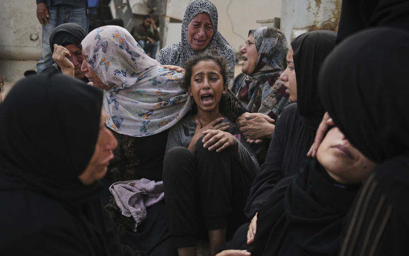 Lian Al-Za'anin, center, is comforted by relatives as she mourns the loss of her father, Rami Al-Za'anin, who was killed while heading to an aid distribution hub, at the morgue of the Shifa Hospital in Gaza City, on Thursday, July 3, 2025. Image: AAP/ AP Photo/Jehad Alshrafi