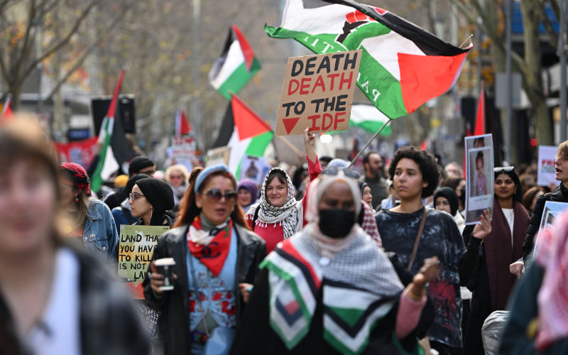 A protester holds up a placard reading ‘death death to the IDF’ at a march during a Pro-Palestine rally at the State Library of Victoria in Melbourne, Sunday, July 6, 2025. Image: AAP Image/James Ross