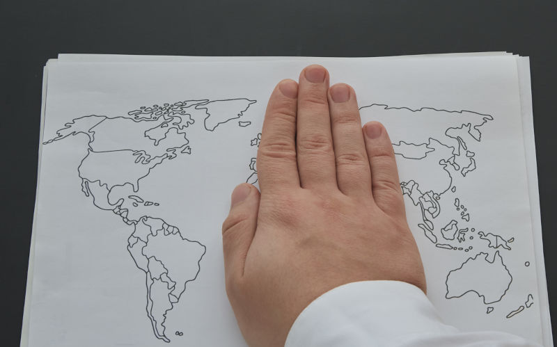 A man's hand covers half of a hand-drawn world map on a white piece of paper. Imperialism, geopolitics and globalisation, conflicts and diplomacy. Image: iStock / Oleksandr Lanevskyi