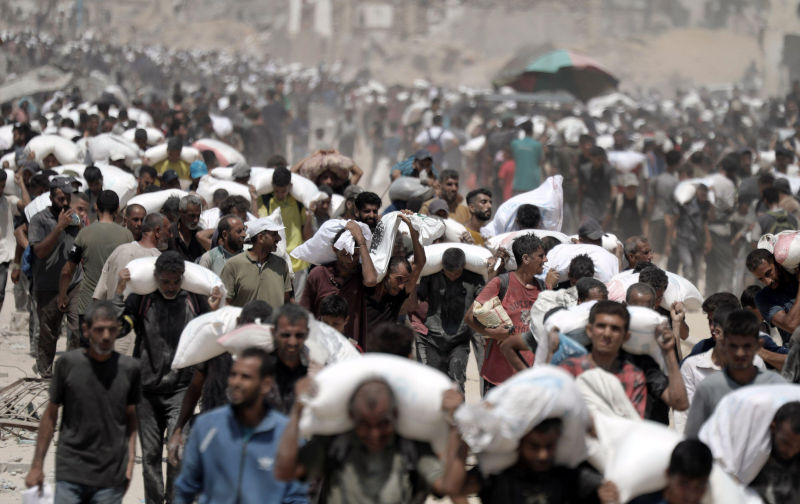 Gaza, Gaza. 27th July, 2025. Palestinians carry sacks of flour after trucks carrying humanitarian aid entered through the Zikim crossing in northern Gaza on Sunday, July 27 2025. Jordan and the United Arab Emirates also parachuted 25 tons of aid into the Gaza Strip on Sunday in their first airdrop in months, a Jordanian official source said. Photo by Mahmoud Issa/UPI Credit: UPI/Alamy Live News. Contributor: UPI Image ID: 3C3WB71