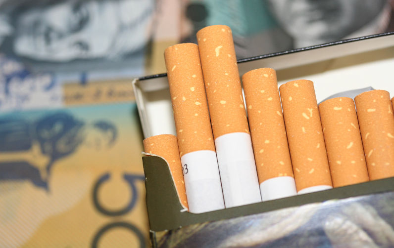 Open packet of expensive cigarettes in front of Australian fifty and twenty dollar notes. Image: iStock / istock80