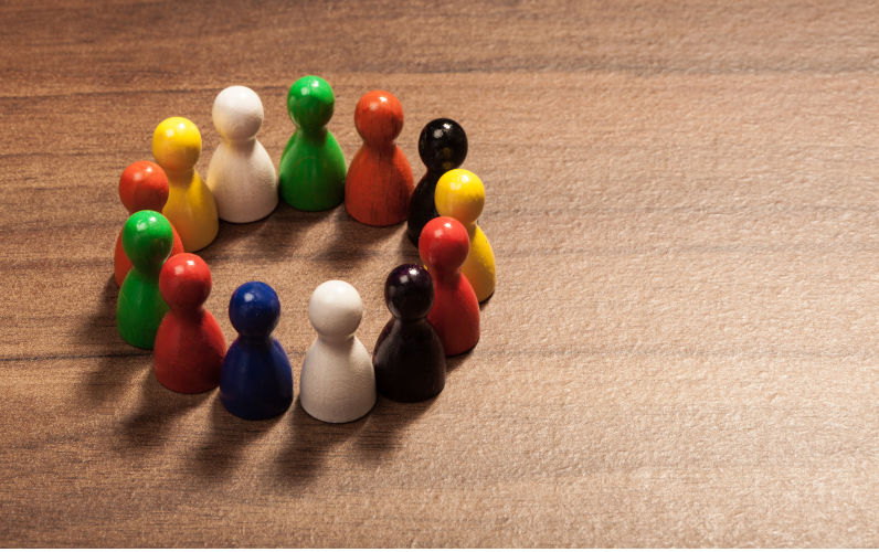 Circle of diversity, friends, colourful toy pawns. Concept. Image: iStock / MichaelJay