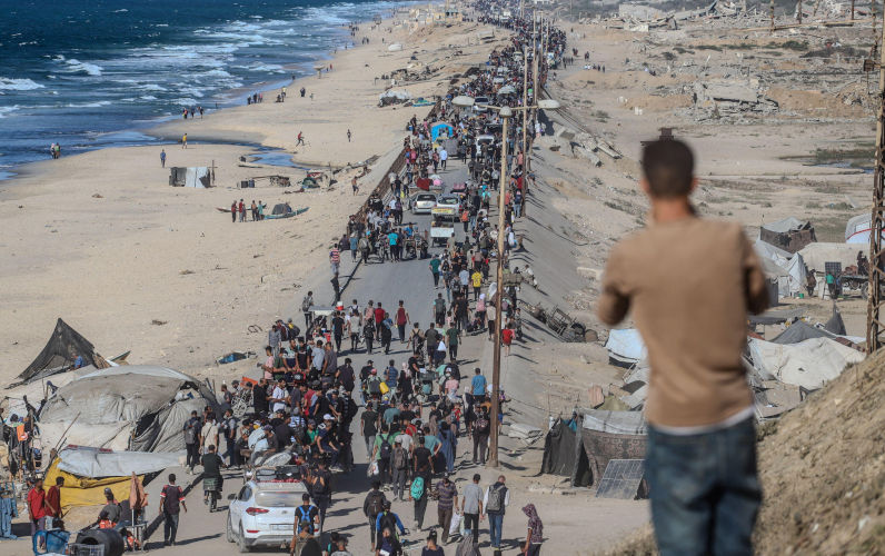Palestine. 10th Oct, 2025. Palestinians walk along alRashid Street, the main coastal road connecting southern and central Gaza to the north, as they return to their homes following the new ceasefire agreement between Israel and the Palestinian group Hamas in Gaza City, Gaza, on October 10, 2025. Photo by Ramez Habboub/ABACAPRESS.COM Credit Abaca Press/Alamy Live News. ContributorAbaca Press. Image ID3CWCCTD