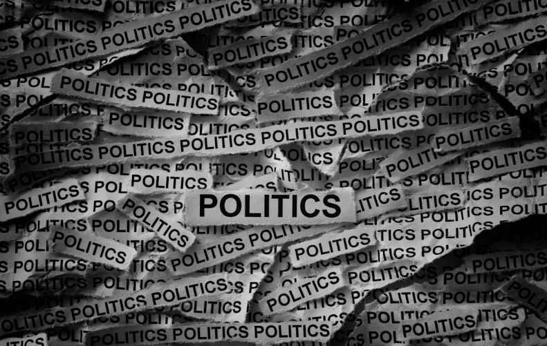 Strips of newspaper with the words Politics typed on them. Black and white. Close up. Image iStock / CreditProfessor25