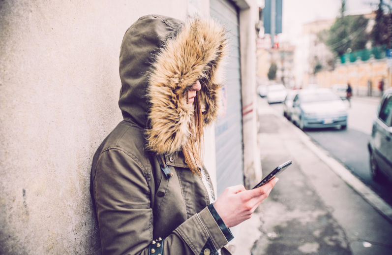 Young woman on her own in urban laneway. Image iStock CasarsaGuru
