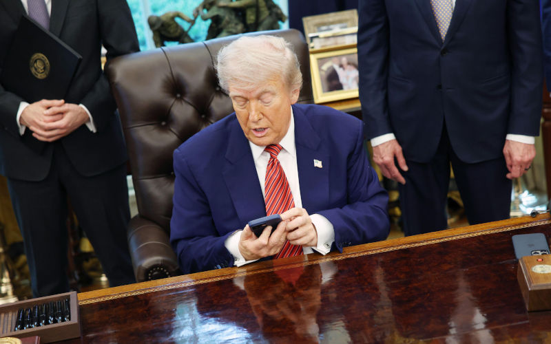 Washington, United States Of America. 23rd May, 2025. United States President Donald J Trump checks his phone as he signs executive orders regarding nuclear energy in the Oval Office of the White House in Washington, DC, US, on May 23, 2025. Trump signed a total of five executive orders aimed at easing restrictions and expanding the nuclear energy industry. Credit Samuel Corum Pool via CNP AdMedia Newscom Alamy Live News IMage ID3BE4YE8