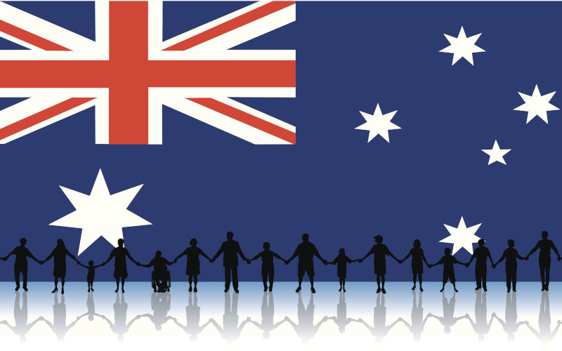 Australians in silhouette standing together with the flag in the background. Illustration. Image iStock KeithBishop
