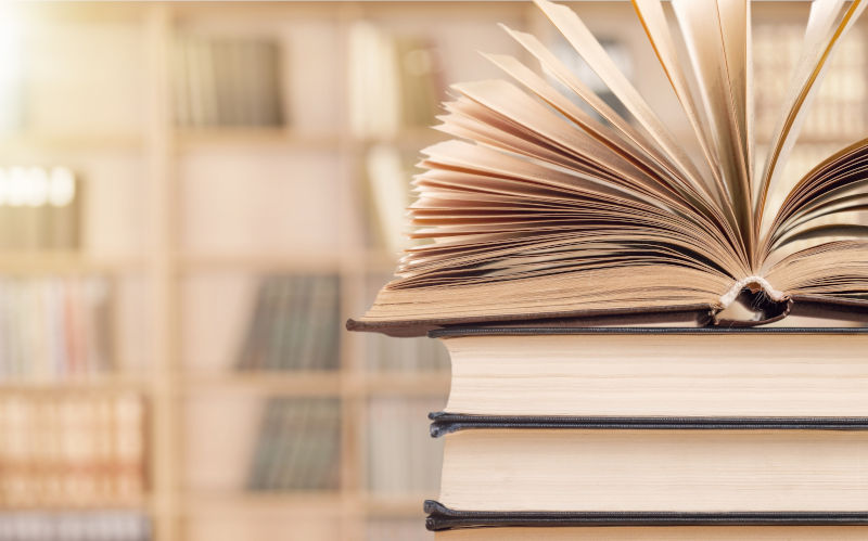 Books stacked and shelves in the background. Image iStock artisteer