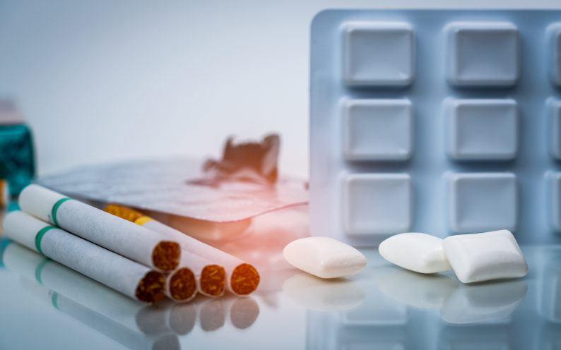 Nicotine chewing gum in blister pack near pile of cigarette. Quit smoking or smoking cessation and lung cancer concept. 31 May World no tobacco day. Image iStock Fahroni