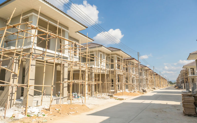 Construction new housing in progress at building site housing estate development. ImageiStock