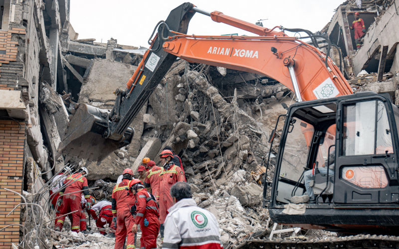 Rescue workers search rubble of destroyed residential buildings following U.S.Israeli airstrikes, Tehran, Iran. March 25, 2026 Image Alamy fooroogh taherkhani Image ID 3ECRRNP