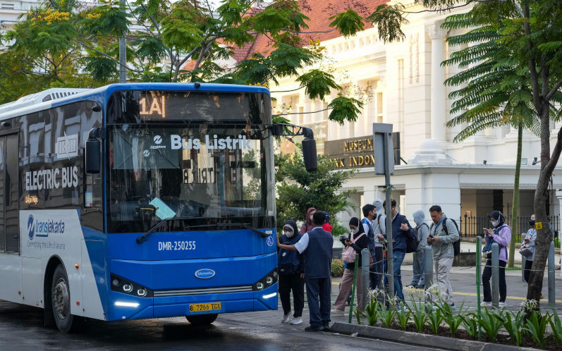 Jakarta, February 3, 2026 A blue TransJakarta electric bus picks up passengers near the historic Museum Bank Indonesia. Image Nazuwa Alamy ID 3EAHRTM