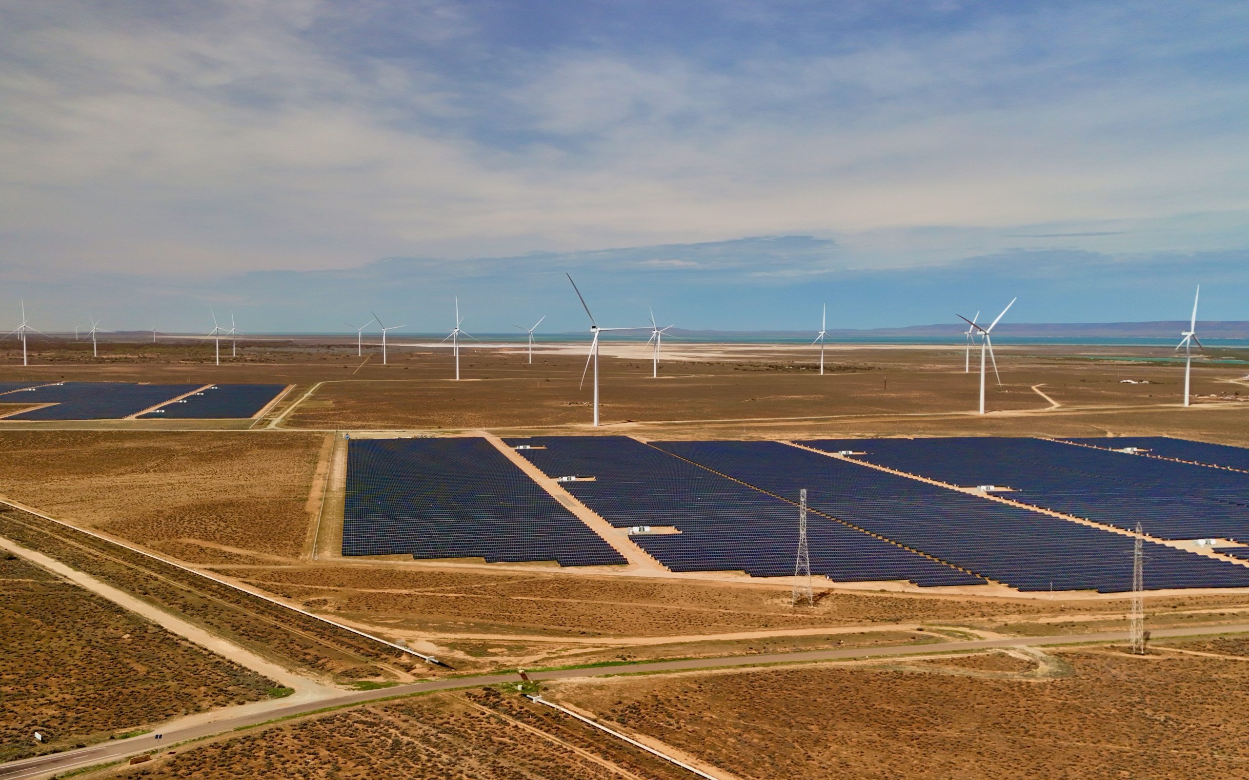 This aerial drone image captures the renewable energy hub at Port Paterson, South Australia, showcasing vast solar panel arrays and towering wind turbines set against the arid desert plains near the Spencer Gulf coastline. The footage highlights Australias commitment to sustainable power generation through solar and wind energy integration in one of the countrys most significant renewable energy corridors near Port Augusta. Image iStock iTraveller