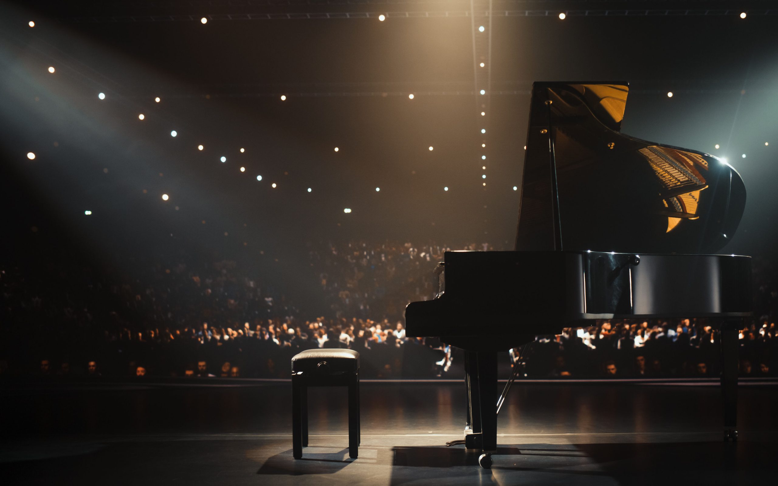 Black Grand Piano Standing on a Concert Stage Under Spotlights. Image iStock gorodenkoff