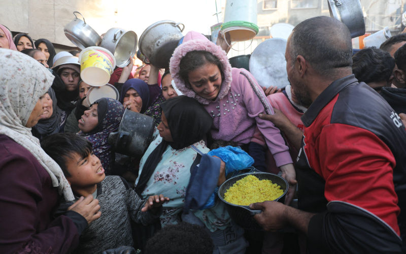 Displaced Palestinian families gather to receive free meals from a charity kitchen in the Nuseirat refugee camp. The suspension of operations by many international humanitarian organizations in the Gaza Strip, due to Israeli restrictions and reduced aid entry, has exacerbated the suffering of residents and deepened the food crisis within the camps. March 3, 2026. Image IMAGO Moiz Salhi apaimages Alamy Image ID 3DXHF2P