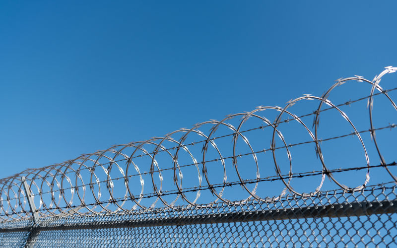 Prison security fence under a blue sky. Image iStock photosvit