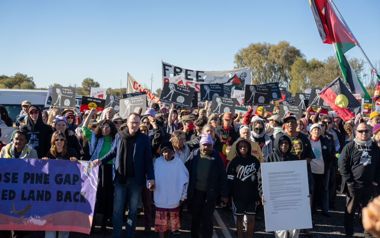 Hundreds of protesters convoy during the three day Close Pine Gap symposium in Alice Springs, Northern Territory, Monday, July 20, 2026. Those gathered are calling for the closure of the US military intelligence base Pine Gap, for an end to the US alliance, and for the sacred land the base occupies to be returned to Arrernte custodians, who never consented to the base. Image AAP Rhett Hammerton