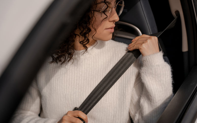 Woman buckles down seat belt in car. Image IStock AVI stock