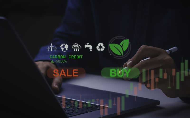 Businessman uses technology to exchange carbon credits on virtual screen with net zero emissions, clean technology, renewable energy. Image iStock CreditTanankorn Pilong