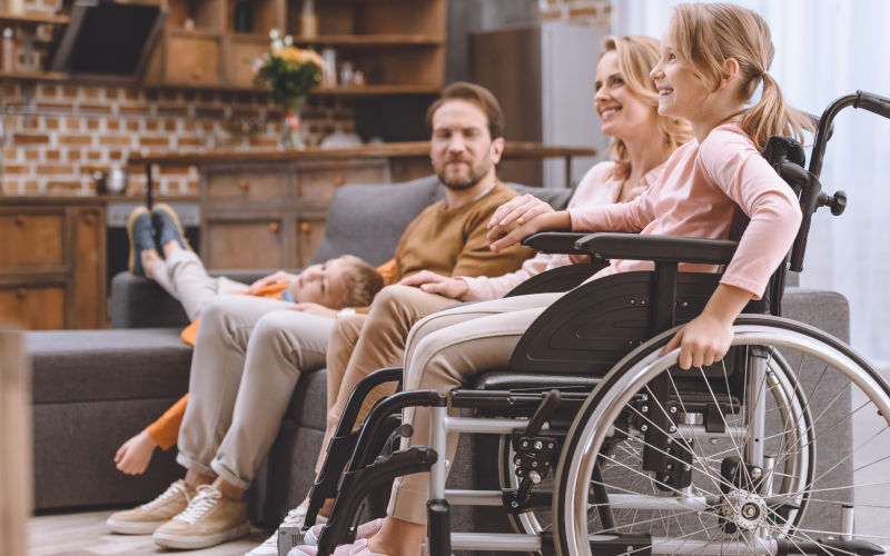 Family at home with daughter in wheelchair. Image iStock LightFieldStudios
