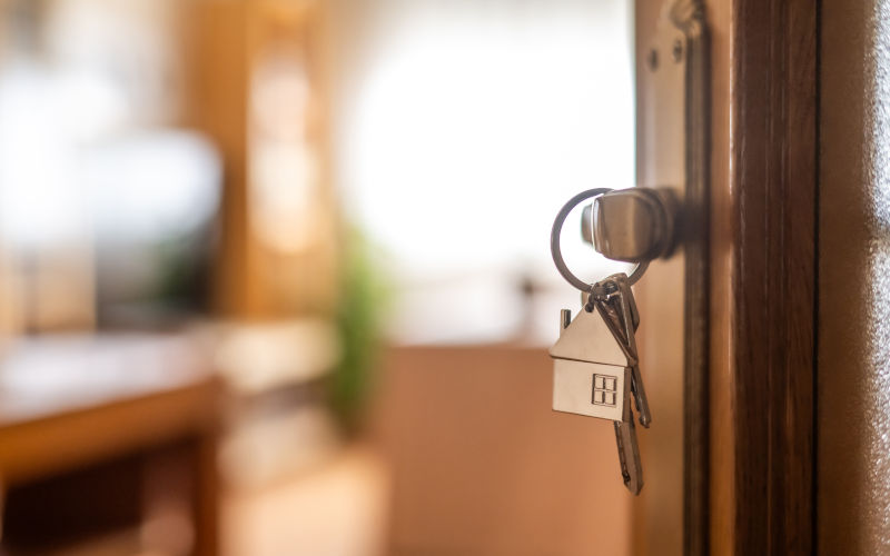Houseshaped keys are hanging from the door knob of a new home, representing the exciting moment of acquiring property and starting a fresh chapter. Image iStock Nanci Santos