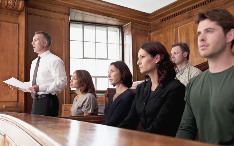 A jury in a courtroom with head juror reading verdict. ImageiStock Chris Ryan