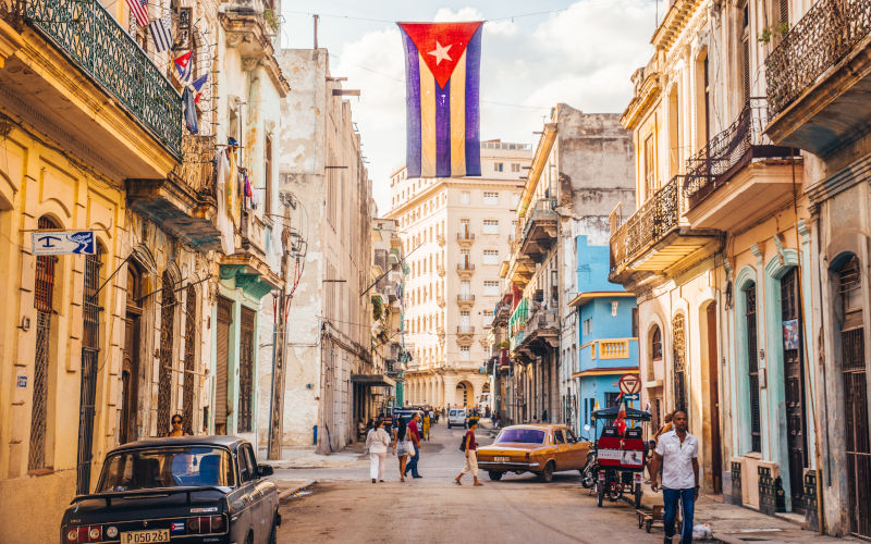 Havana, Cuba December 22, 2015 A Cuban flag with holes waves over a street in Central Havana. Image iStock julianpetersphotography