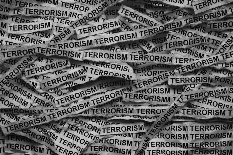Strips of newspaper with the words Terrorism typed on them. Black and white. Image iStock Professor25