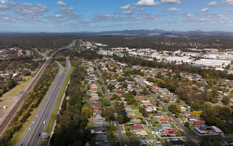 Carole Park, located in the City of Ipswich, Queensland, is a major industrial suburb within the Brisbane Ipswich growth corridor. This aerial drone footage captures large warehouses, distribution centres, and logistics hubs surrounded by green forest. Key road infrastructure includes the Logan Motorway, linking Carole Park to Brisbane and Ipswich. The nearby residential suburb of Ellen Grove highlights the contrast between industrial zones and suburban living. Image iStock iTraveller