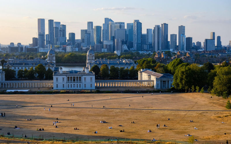 UK Summer 2026A vast expanse of yellowed grass over Greenwich Park overlooking Queens House and the Canary Wharf towers in the distance. Image Alamy Eleventh Hour Photography Image ID 3FBF3B9