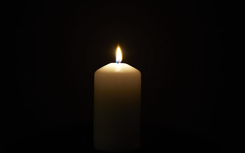 Candle on black background, symbolising death, grief, loss. Image Thomas Stockhausen